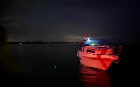 En motorbaad med en smilende redder fra DSRS København om bord i nattens mørke