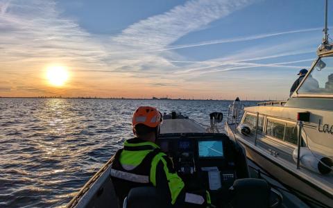 Rescue Njord med havaristen på siden sejler mod solnedgangen.